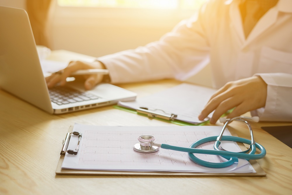 Stethoscope with clipboard and Laptop on desk,Doctor working in